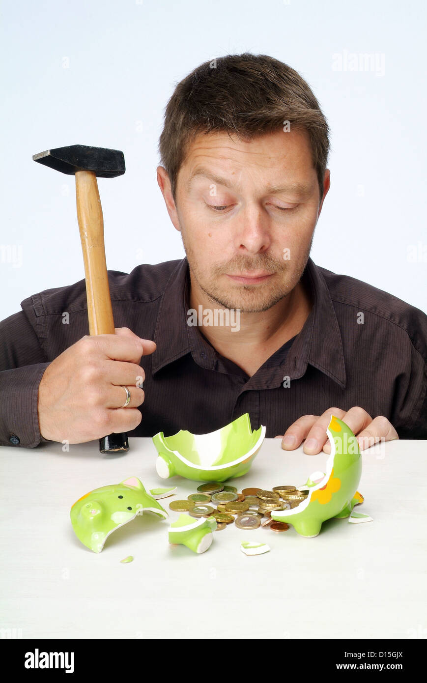 Hamburg, Germany, a man looks to be skeptical slaughtered piggy bank Stock Photo