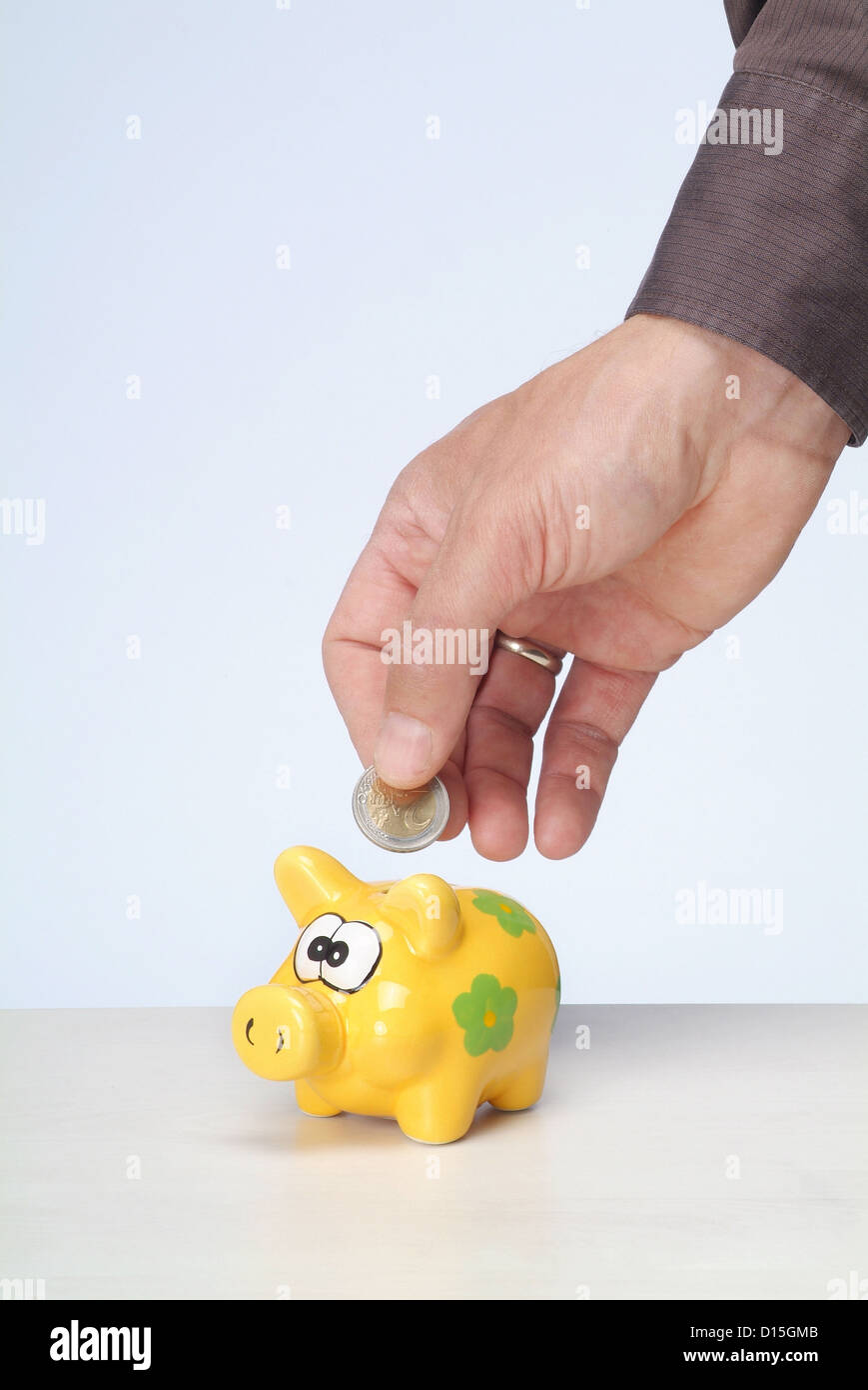 Hamburg, Germany, a Maennerhand put a euro into the piggy bank Stock Photo