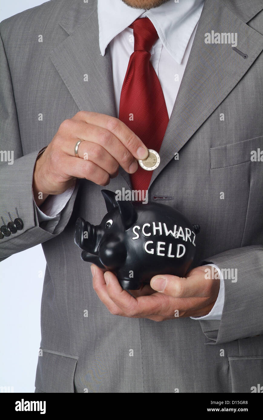 Hamburg, Germany, a man throws a Euromuenze money into a black pig Stock Photo
