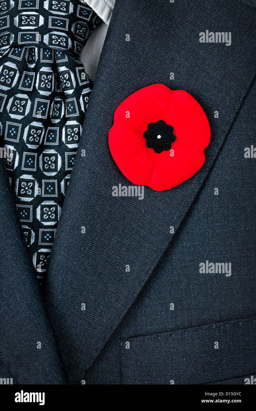 Red poppy lapel pin on suit jacket for Remembrance Day Stock Photo