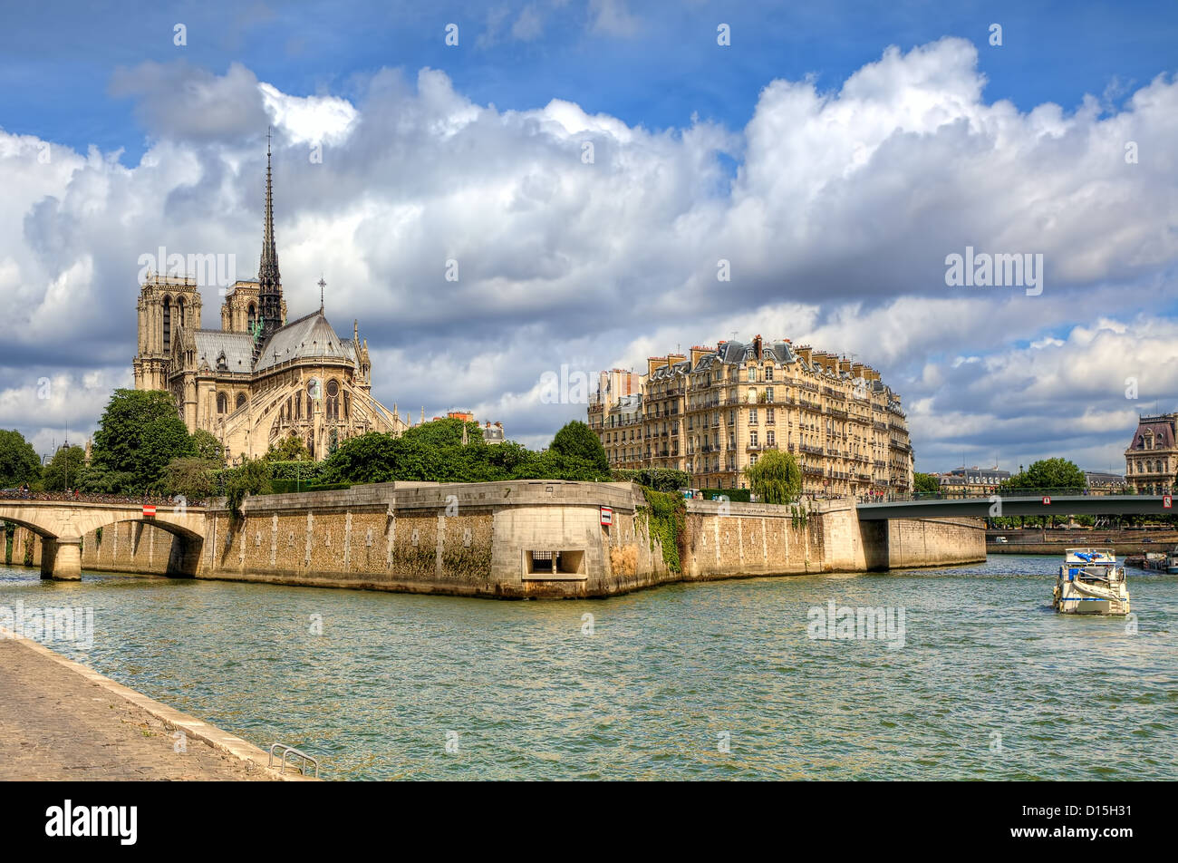 Famous Notre Dame de Paris Cathedral under beautiful cloudy sky in Paris, France (view from Seine river). Stock Photo