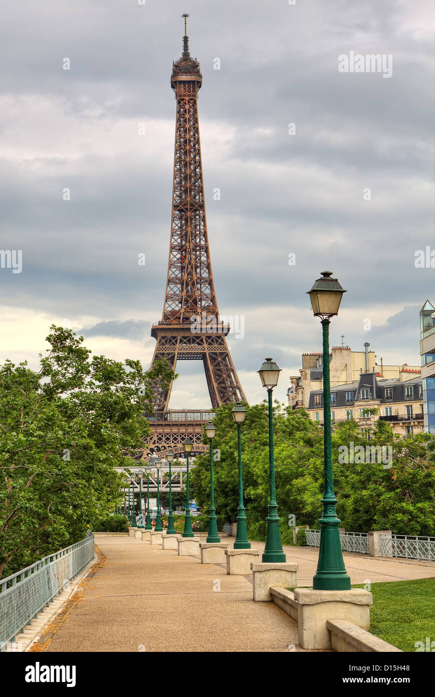 Vertical oriented image of famous Eiffel Tower and traditional urban lampposts in Paris, France. Stock Photo