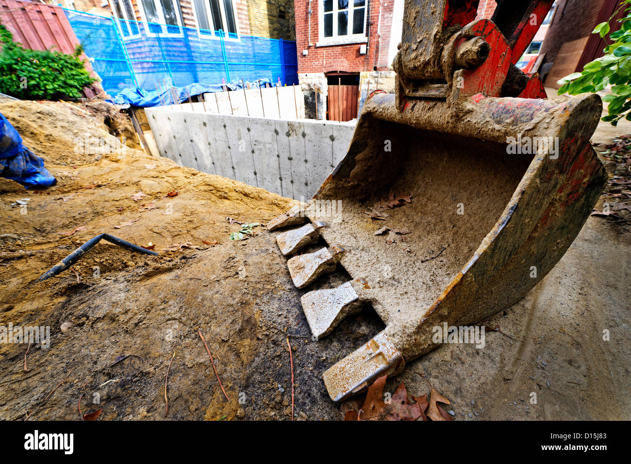 Backhoe scoop at residential home renovation construction site Stock Photo