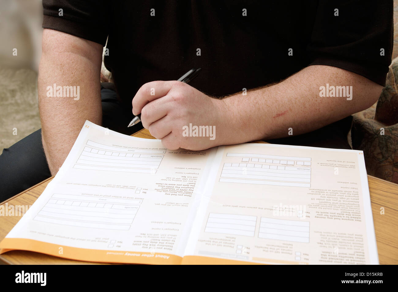 Man filling in an application form to claim for benefits Stock Photo