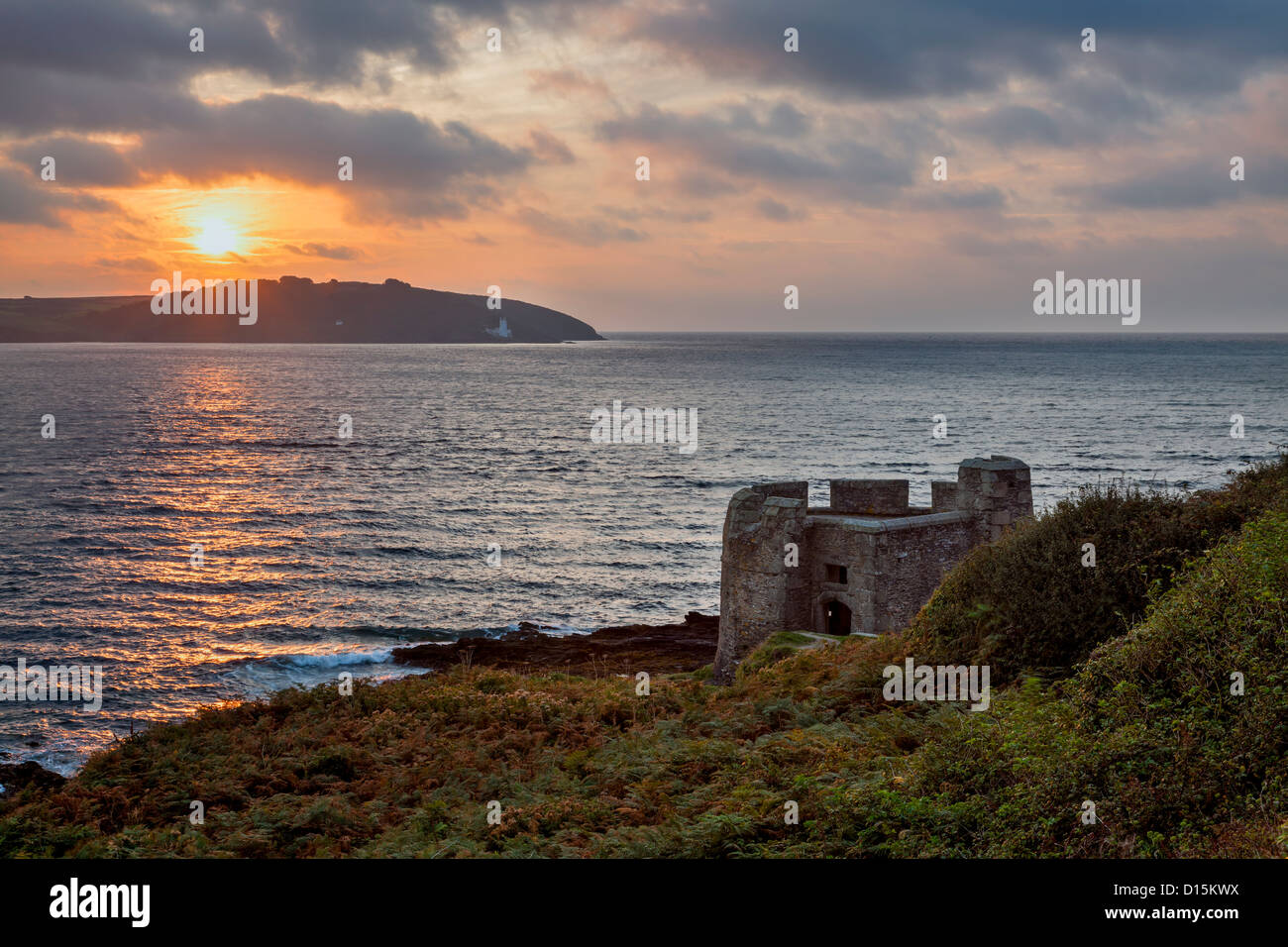 The small block house known as Little Dennis with the sun rising over St Antonys Head, Cornwall England UK Stock Photo