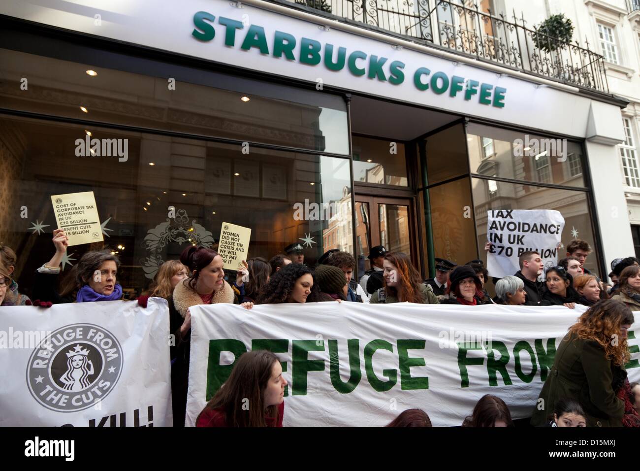 London, Uk. 8th of December 2012 Activists from the group UKuncut and supporters entered a Starbucks on Vigo Street, Mayfair, to protest against alleged tax avoidance by the large coffee chain. Protestors transformed Starbucks into a 'women's refuge' in protest against impact of government’s cuts on women. Stock Photo