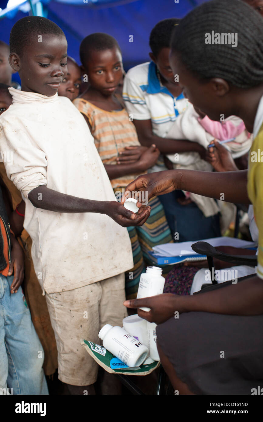 Children queue for deworming medication at an Immunization Outreach Camp in Kitugutu Village, Kyenjojo District, Uganda. Stock Photo
