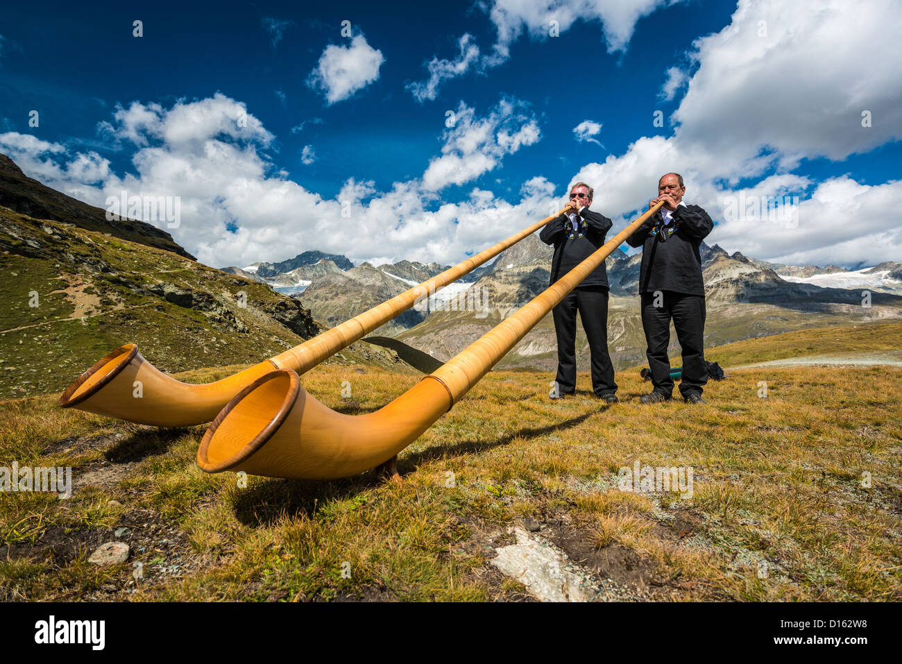swiss-horn-player-in-the-mountains-near-the-matterhorn-D162W8.jpg