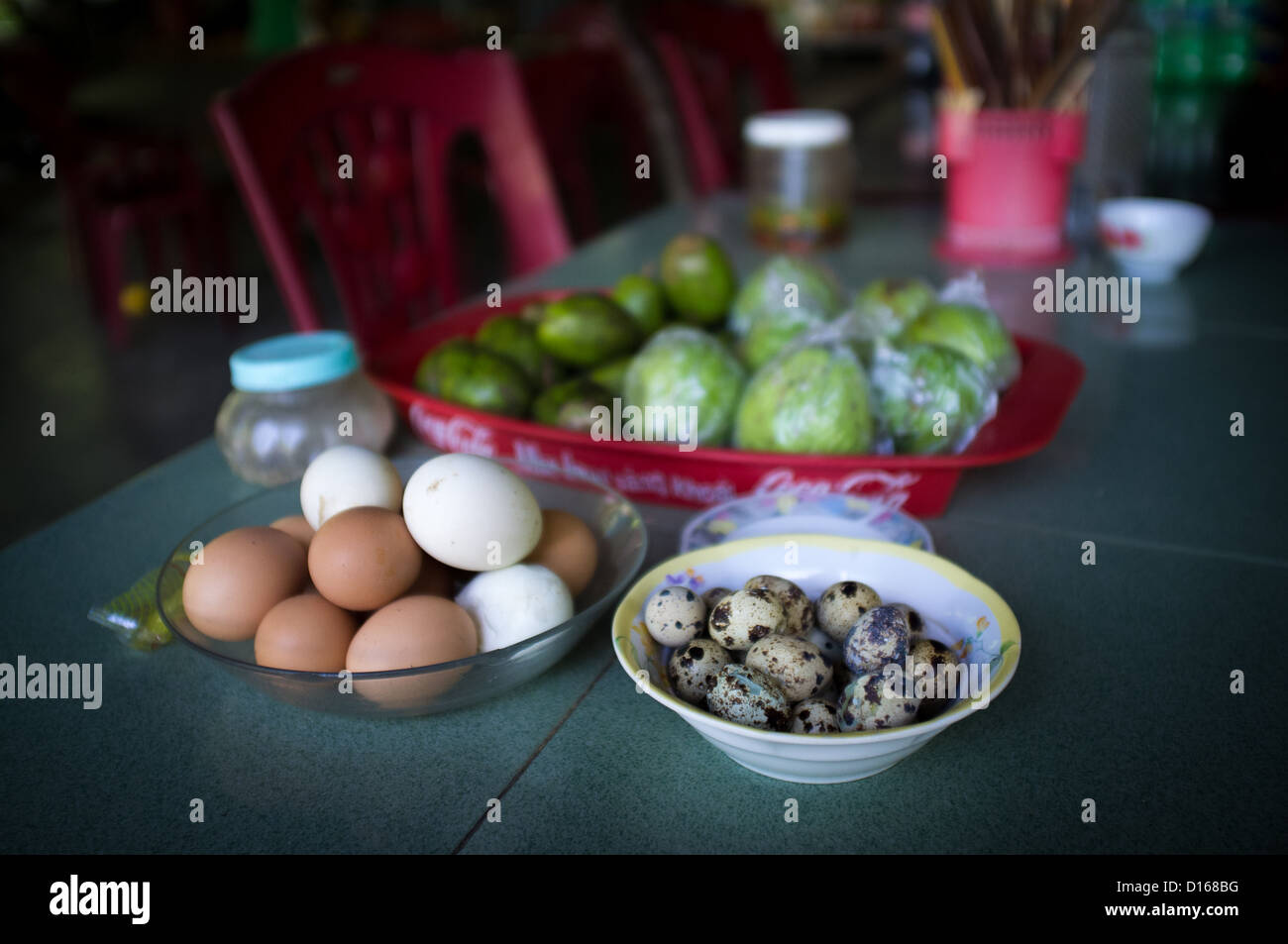 Birds eggs and hens eggs with limes on a roadside cafe table in Vietnam Stock Photo