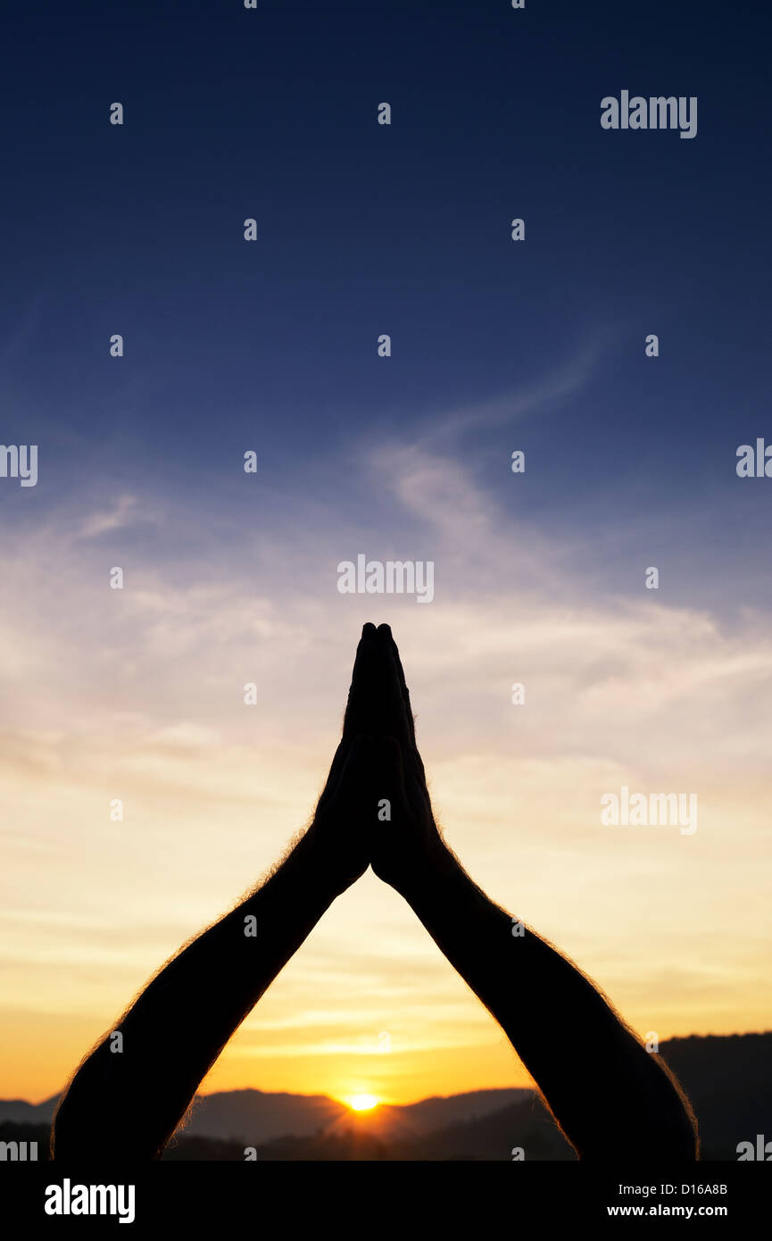 Silhouette of a mans hands praying to the sun. Andhra Pradesh, India Stock Photo