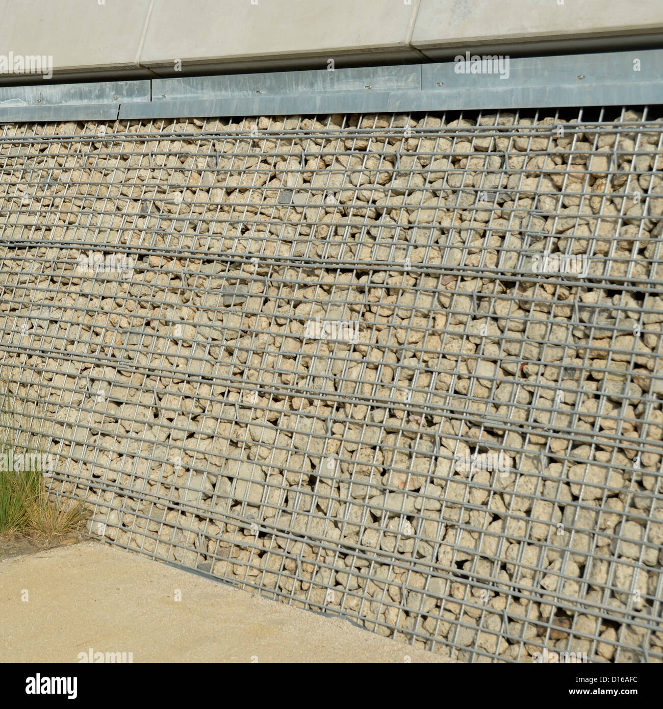 Recycled concrete crushed to form a type of Gabion caged basket used in retaining wall behind a galvanized steel mesh East London England UK Stock Photo