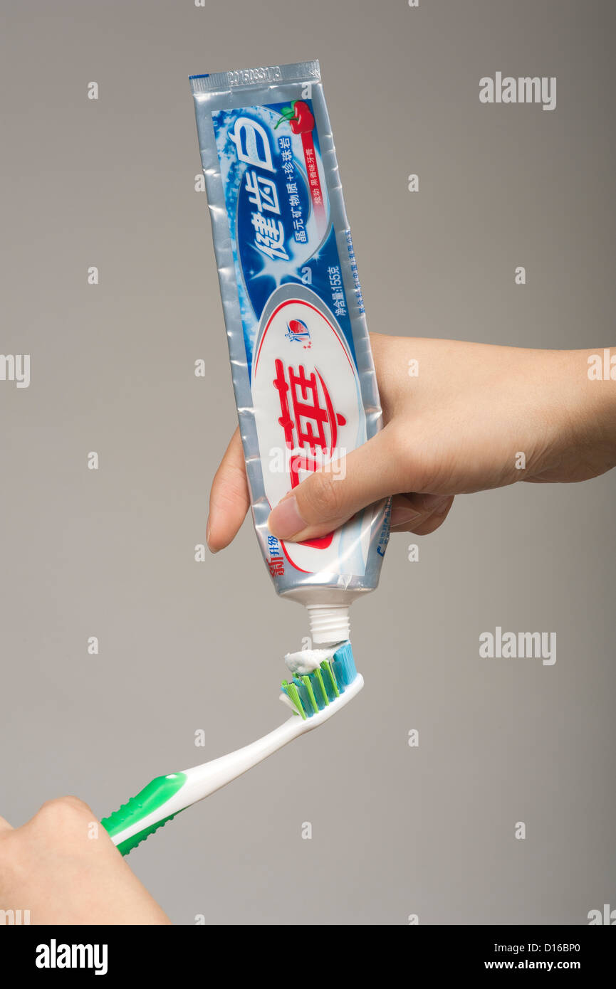 Woman's hand squeezing toothpaste onto a toothbrush Stock Photo Alamy