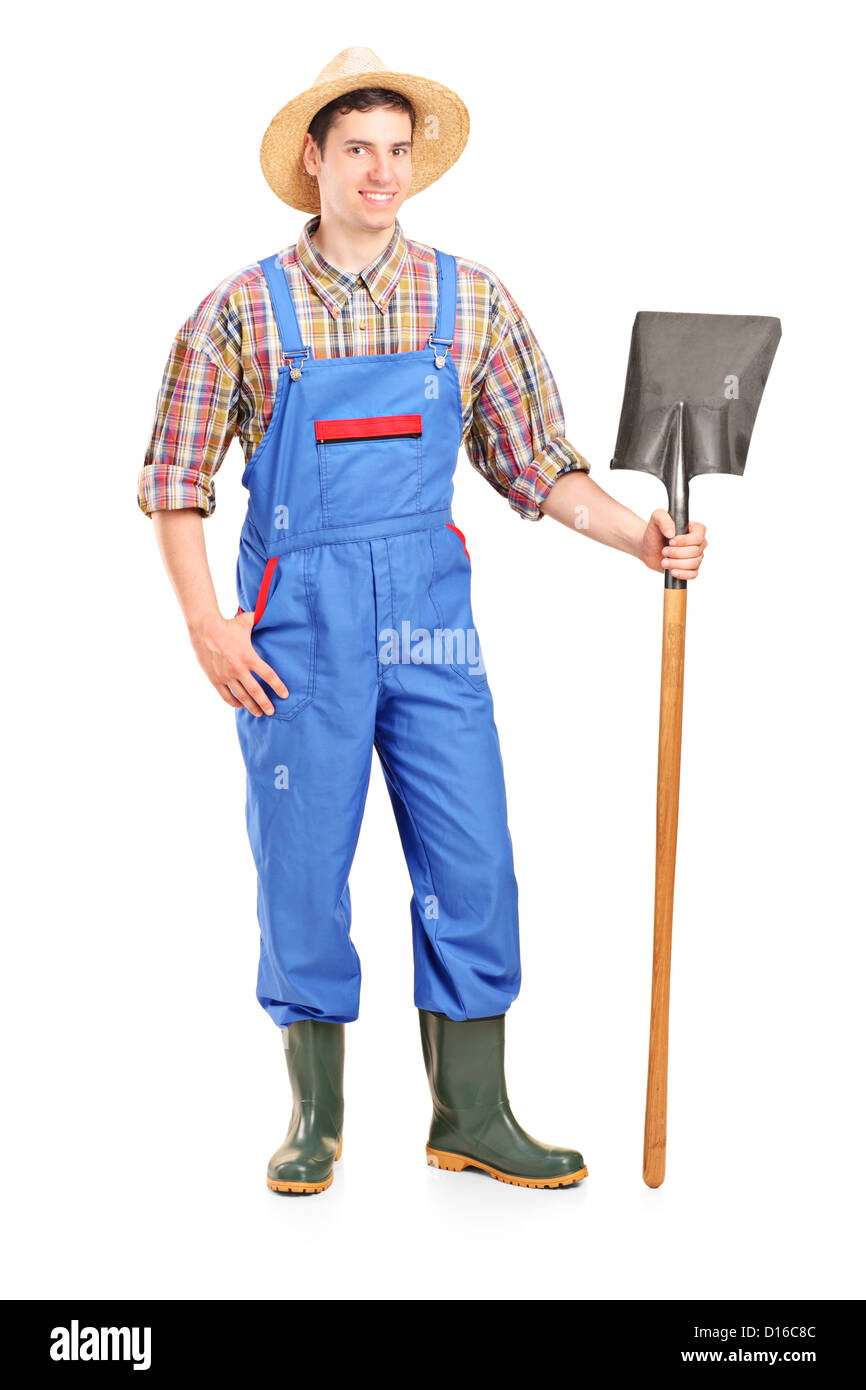 Full length portrait of a male agricultural worker holding a shovel ...