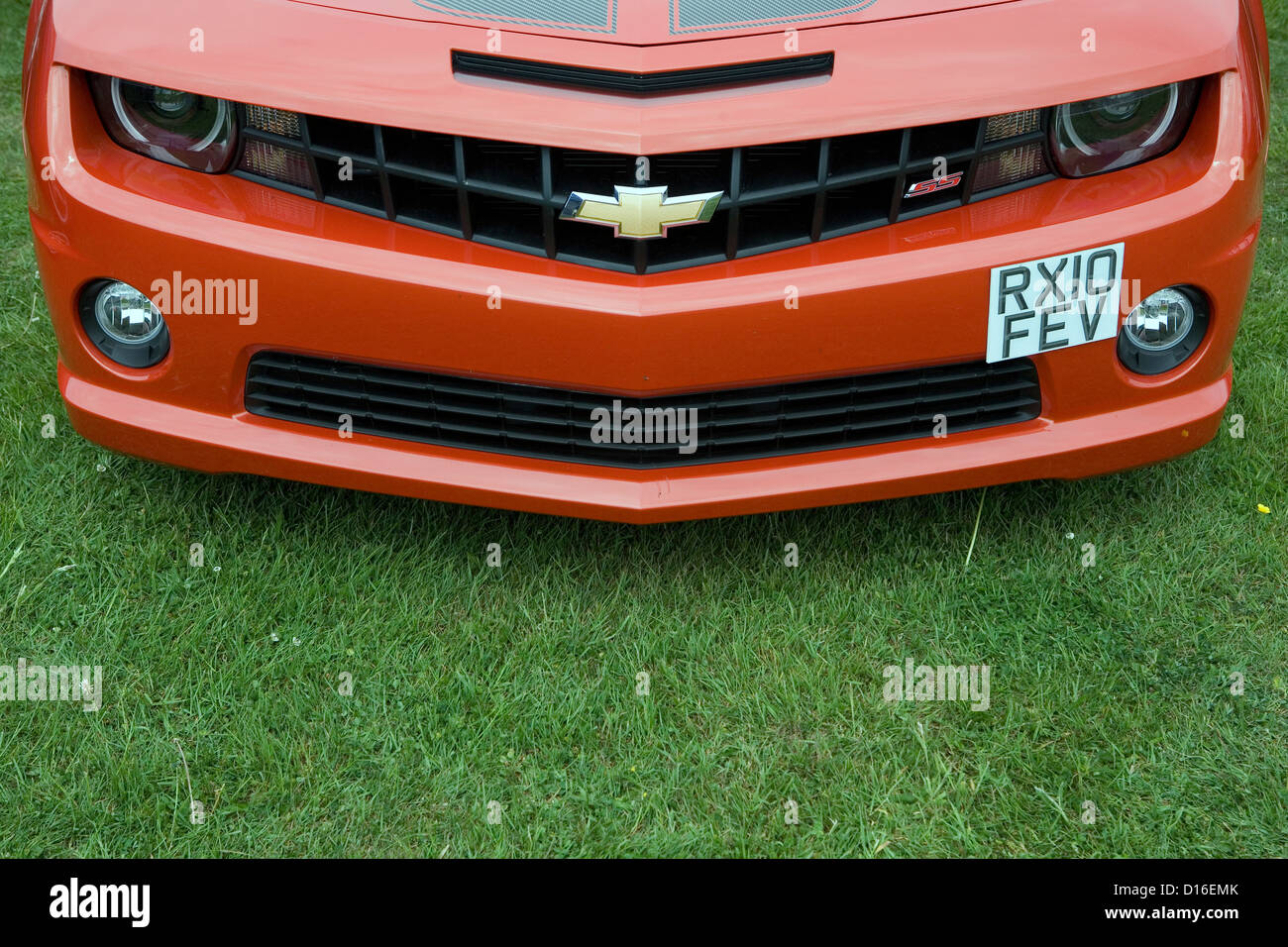 The front of an orange modern Chevrolet muscle car. Stock Photo