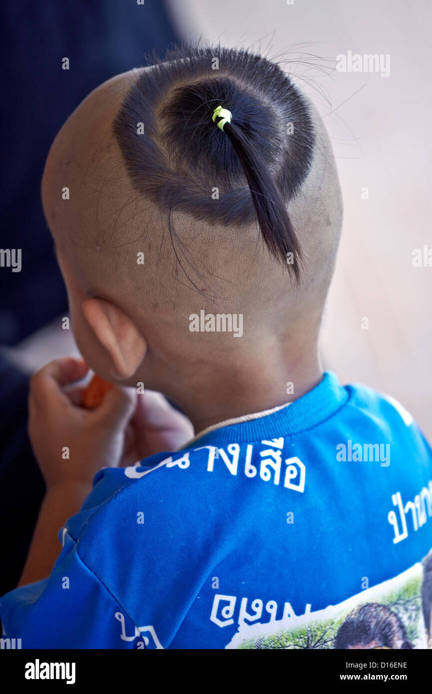 Traditional shaven head and top knot hairstyle on a Thai child. Thailand S.  E. Asia Stock Photo - Alamy