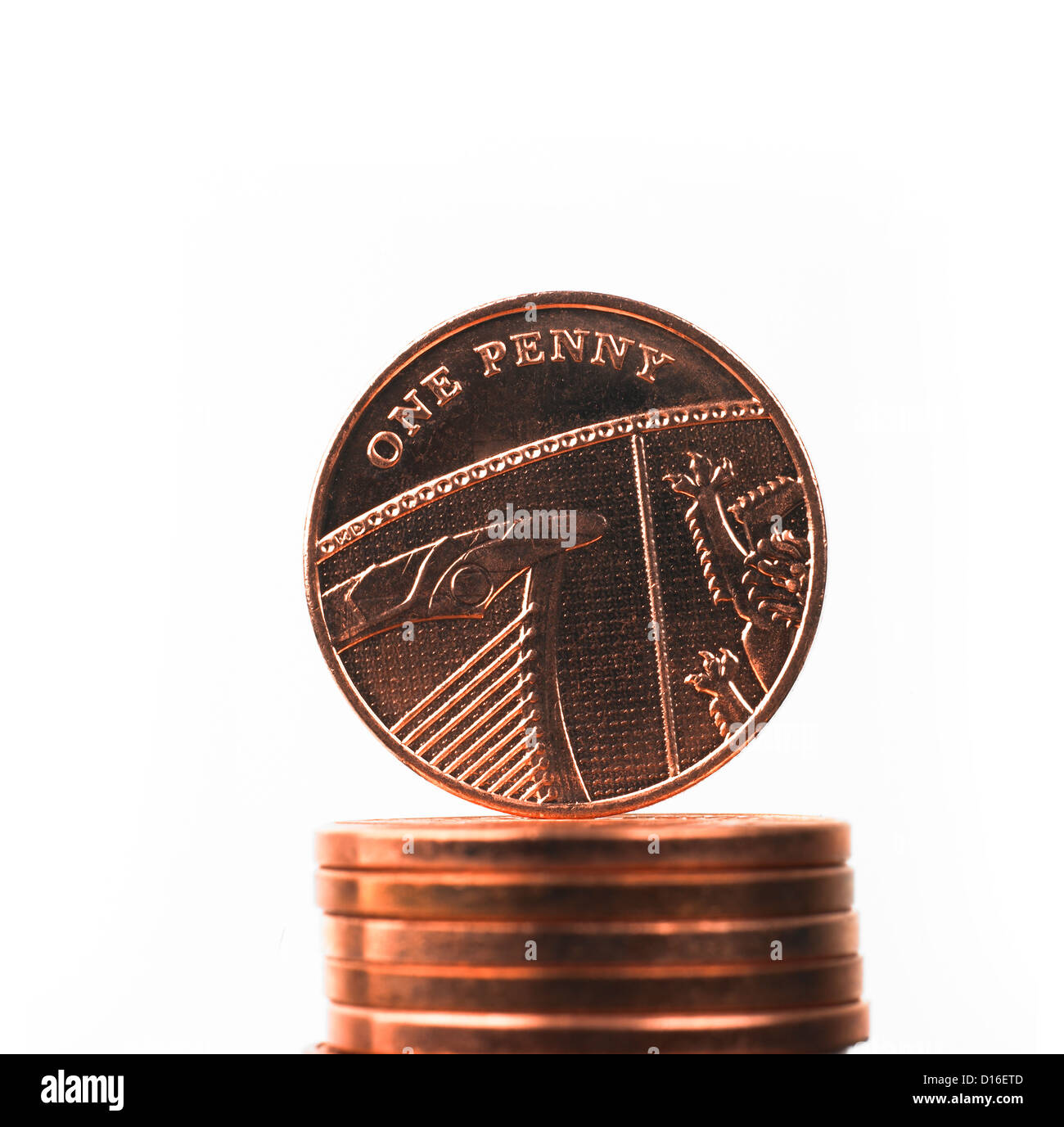 British one penny decimal coin balanced on top of pile of coins Stock
