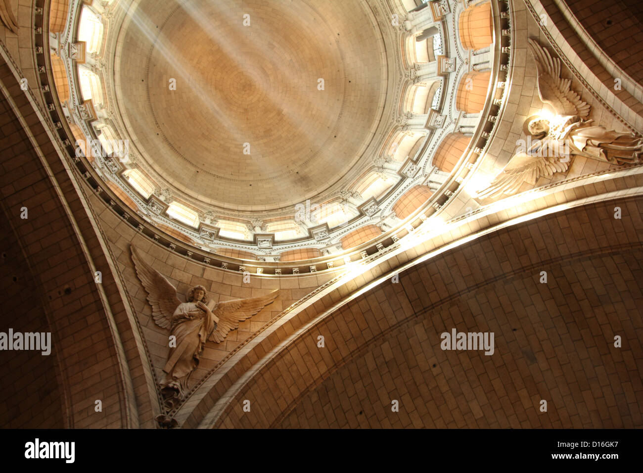 Filtered sunlight lights up angels and dome of Sacre Coeur Basilica, Paris, France Stock Photo