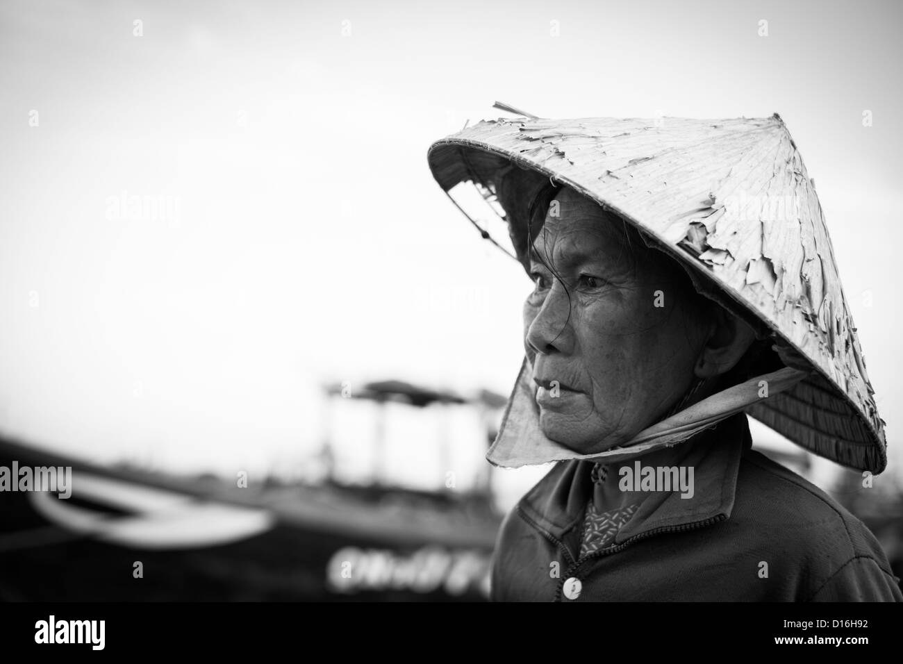 Black and White Image of a Vietnamese Female wearing a tatty bamboo hat Stock Photo