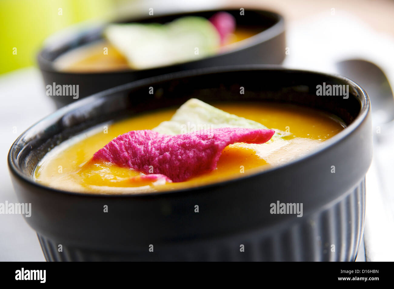 Spicy pumpkin soup, garnished with radish chips. Stock Photo