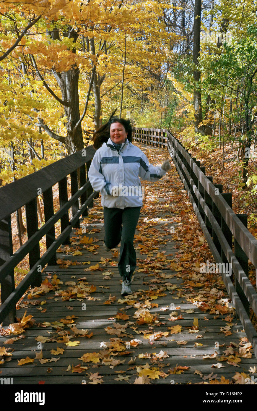 Woman running on a trail in autumn Stock Photo - Alamy