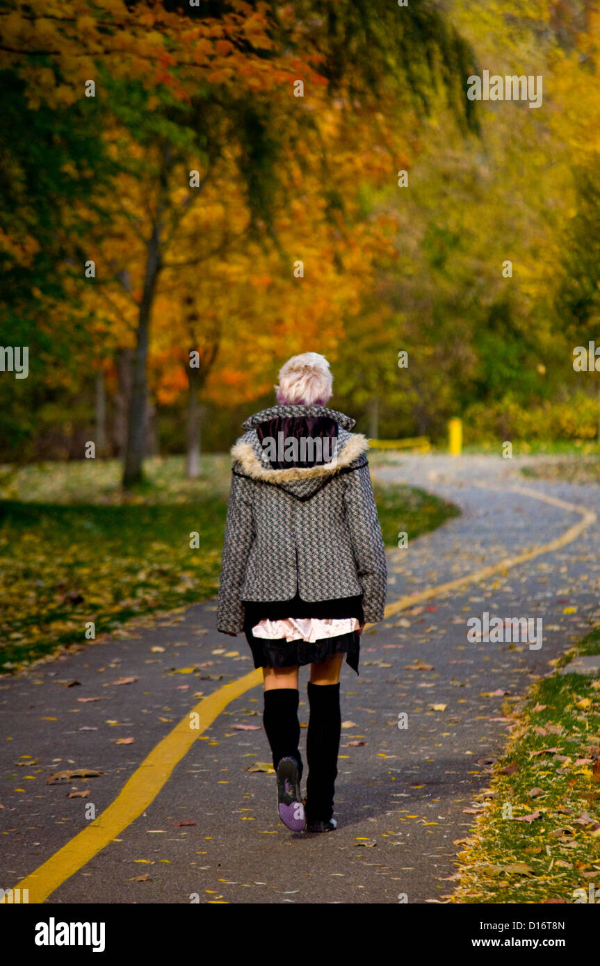 young woman walks in a park -- a typical autumn scene Stock Photo - Alamy