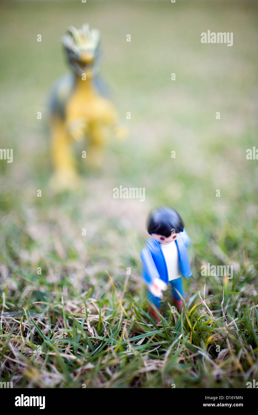 Seville, Spain, Playmobil figure and a dinosaur on a meadow Stock Photo