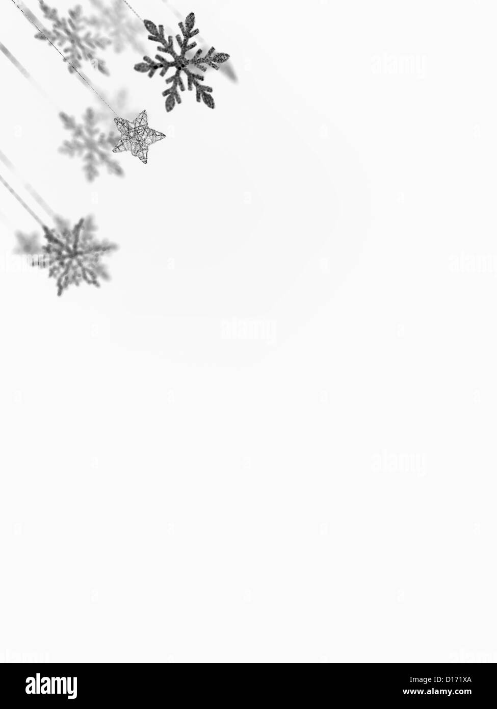 closeup of hanging christmas snowflakes and star decorations, on the upper left corner of the frame, isolated on white Stock Photo