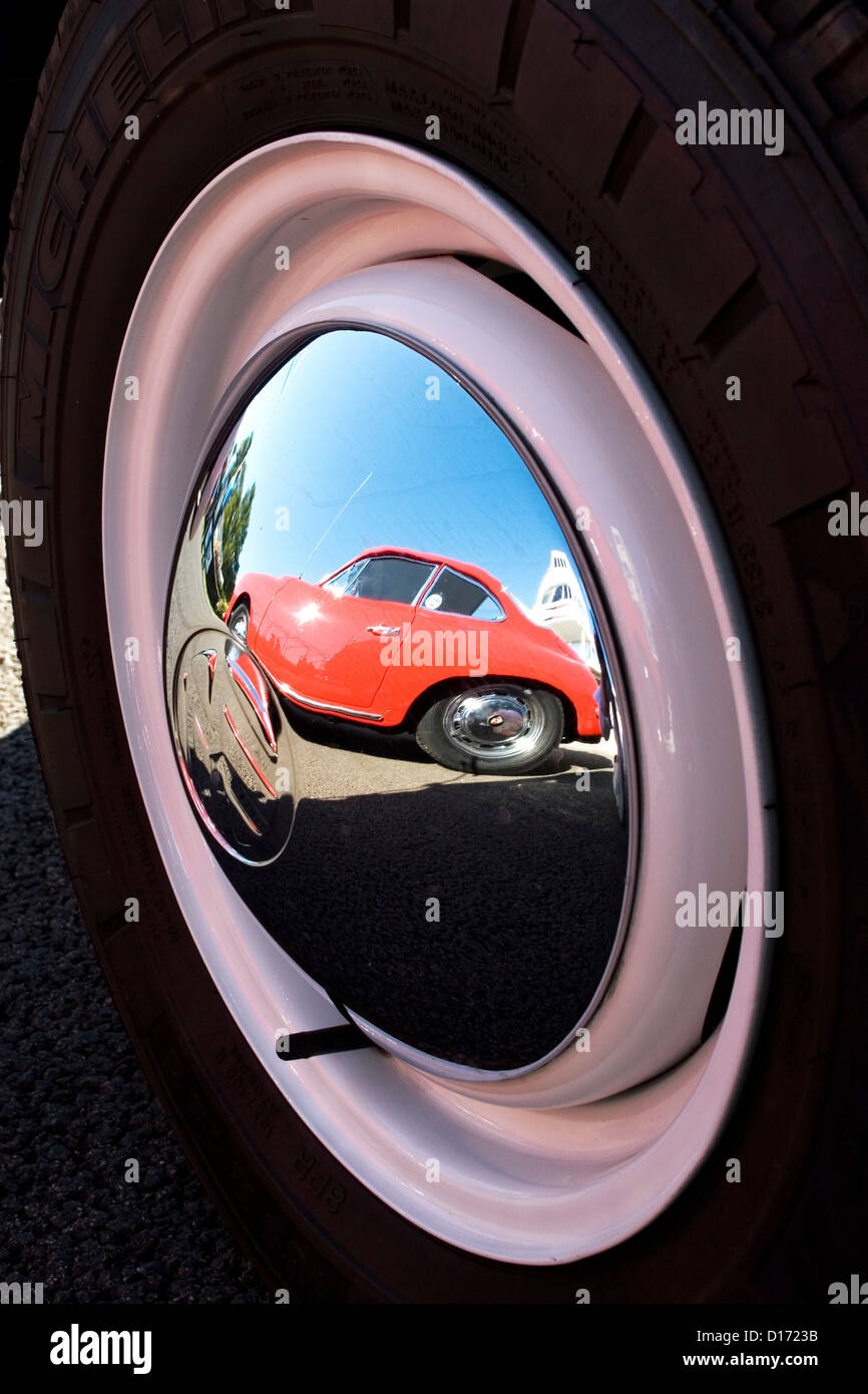 the reflection of a red classic car in a shiny chrome hubcap stock chrome reflection
