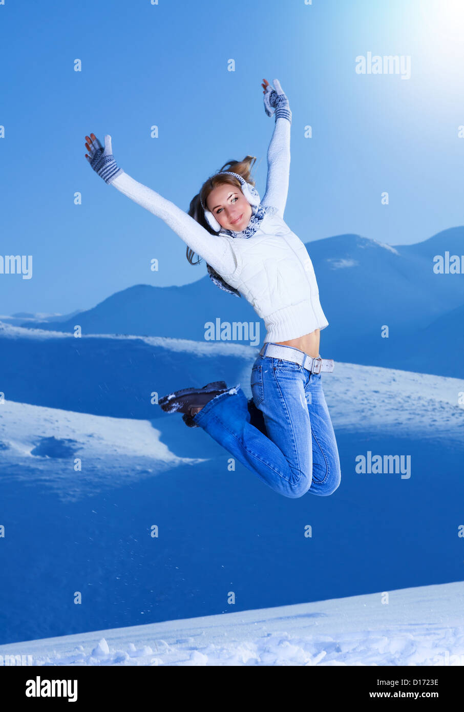 Photo of pretty girl jumping with raised up hands on snowy mountains ...