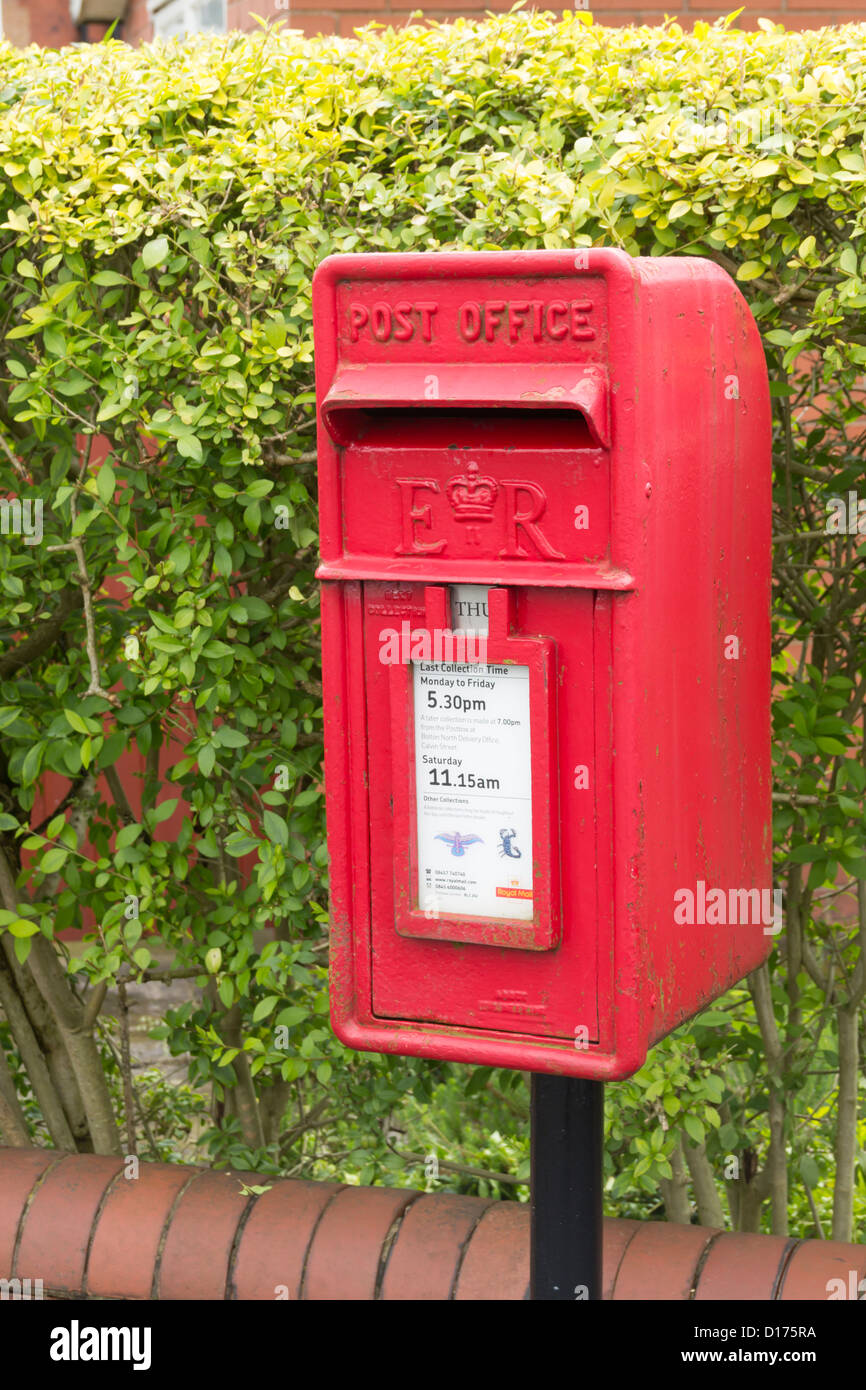 Small standalone post box mounted on a steel post on a street in the suburbs of Bolton. Stock Photo