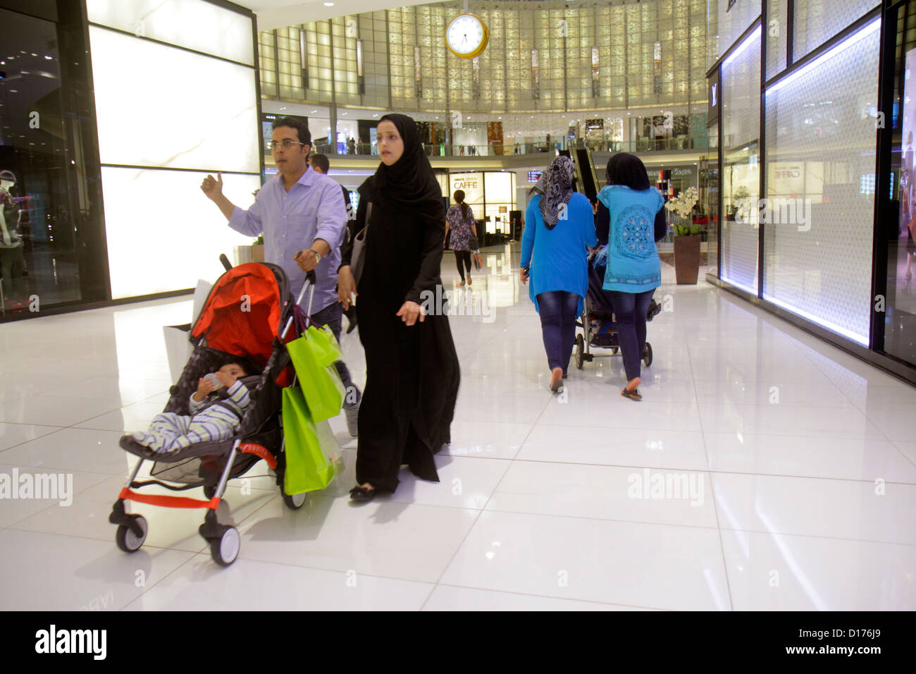 Dubai UAE,United Arab Emirates,Downtown Dubai,Burj Dubai,Dubai mall,atrium,Muslim,woman female women,thawb,robe,hijab,mother,parent,parents,wife,man m Stock Photo