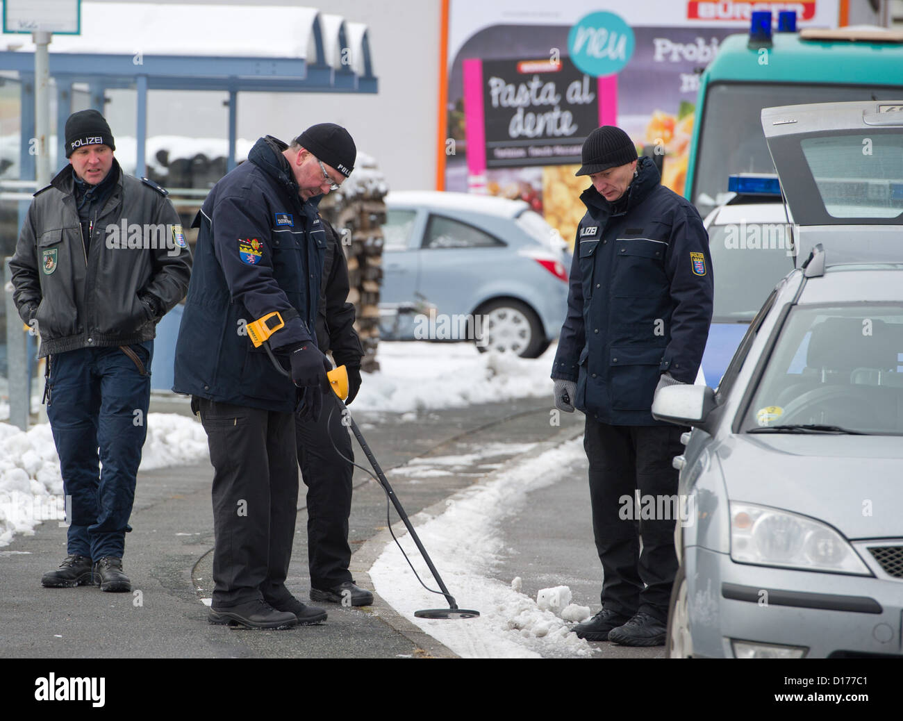 Police officers of the Hesse State Office of Criminal Investigations (LKA) preserve traces and look for bullets after a deadly shooting in a street in Kolmbach, Germany, 07 December 2012. In the early hours of 07 December, a man had wandered the B47 road with a loaded gun and threatened to kill himself. In a shootout with the police the man had been killed. Photo: Boris Roessler Stock Photo