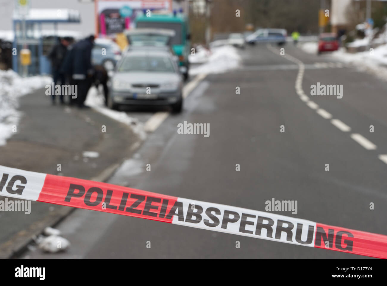 Police officers of the Hesse State Office of Criminal Investigations (LKA) preserve traces and look for bullets after a deadly shooting in a closed-off street in Kolmbach, Germany, 07 December 2012. In the early hours of 07 December, a man had wandered the B47 road with a loaded gun and threatened to kill himself. In a shootout with the police the man had been killed. Photo: Boris Roessler Stock Photo