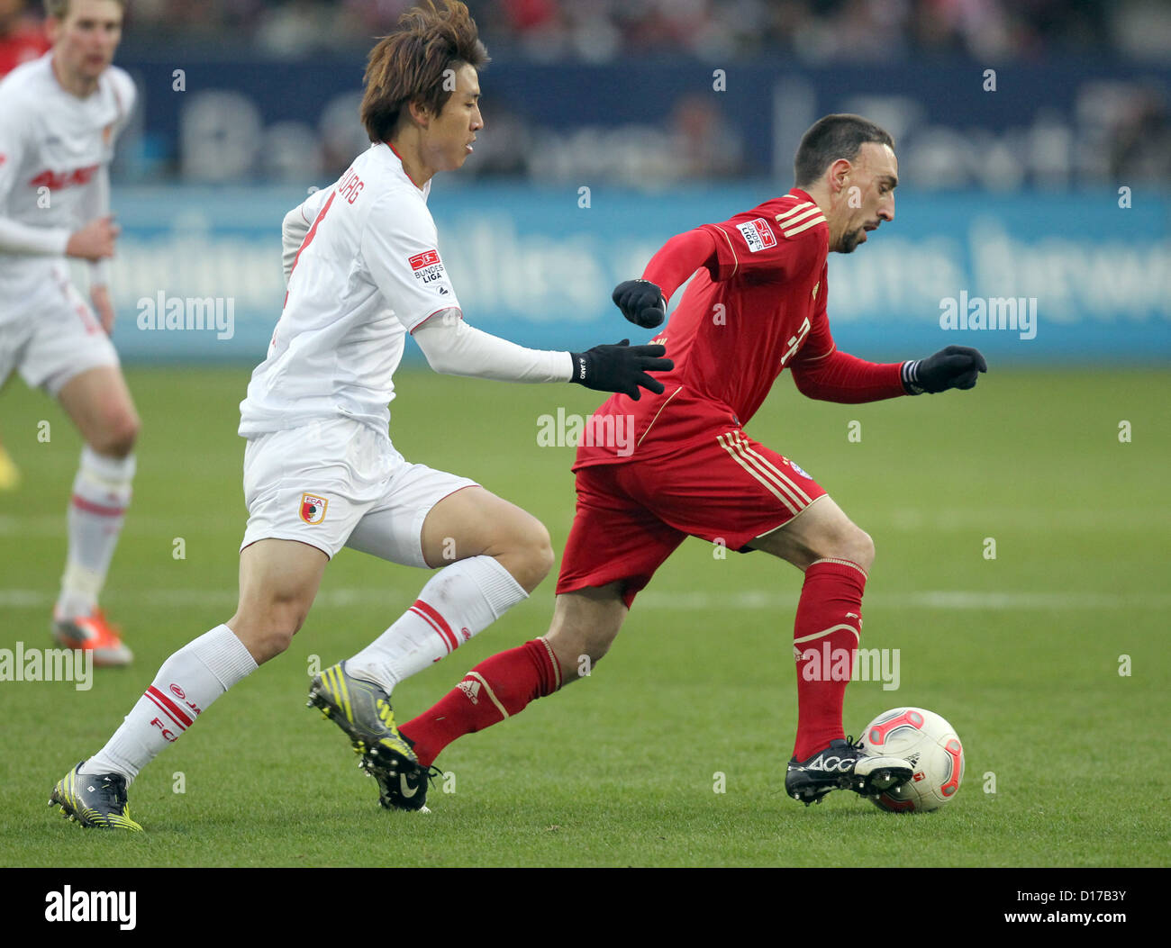 Augsburg's Ja-Cheol Koo (L) vies ball with Munich's Franck Ribery during Bundesliga soccer match between FC Augsburg Bayern Munich SGL Arena in Augsburg Germany 08 December 2012 Augsburg's Kevin Vogt (L) looks on Photo: KARL-JOSEF HILDENBRAND (ATTENTION: EMBARGO CONDITIONS! DFL permits further utilisation up 15 pictures only (no sequntial pictures or video-similar series pictures allowed) via internet online media during match (including halftime) taken inside stadium and/or prior start match DFL permits unrestricted transmission digitised recordings during match exclusively internal Stock Photo