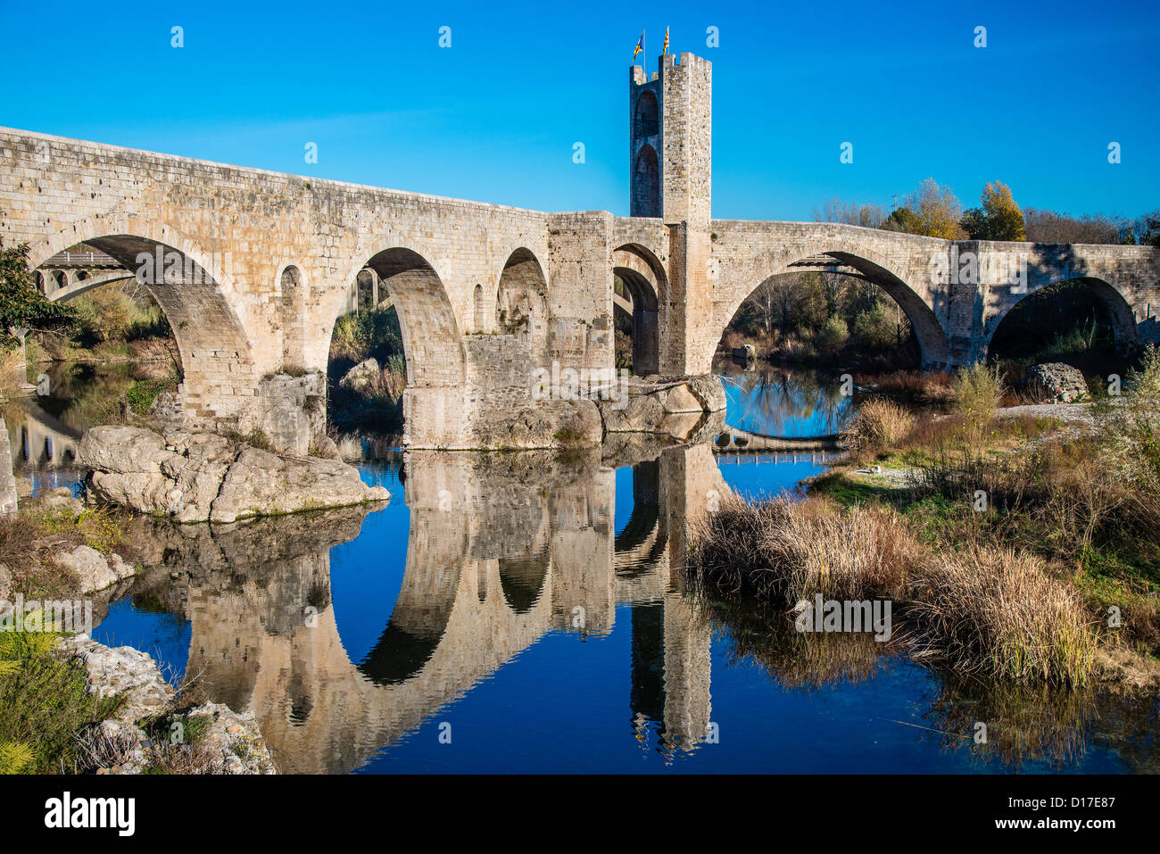 The old Romanic stone bridge reflected into the Fluvià river, Besalú, Catalonia (Spain) Stock Photo