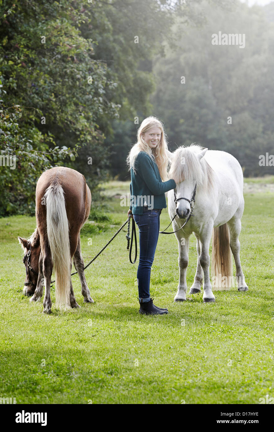 Girl walking horses in field Stock Photo Alamy