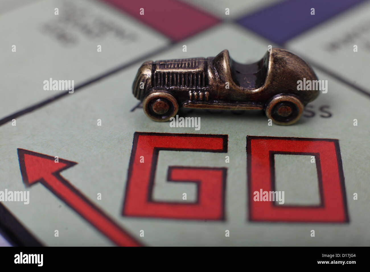 A car players piece on the Go square of a Monopoly board. Stock Photo