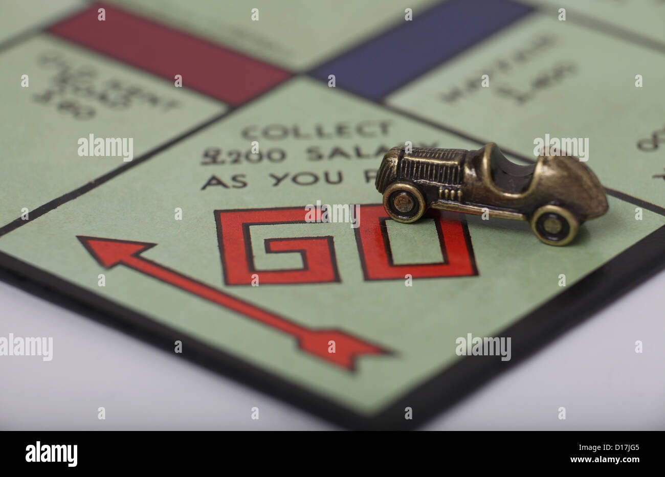 A car players piece on the Go square of a Monopoly board. Stock Photo