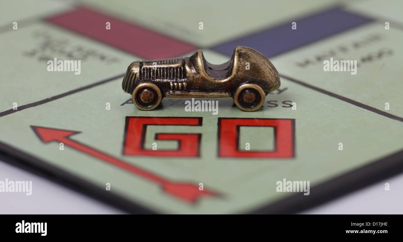 A car players piece on the Go square of a Monopoly board. Stock Photo