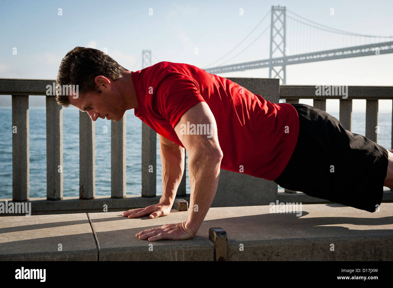 Man exercising on city street Stock Photo