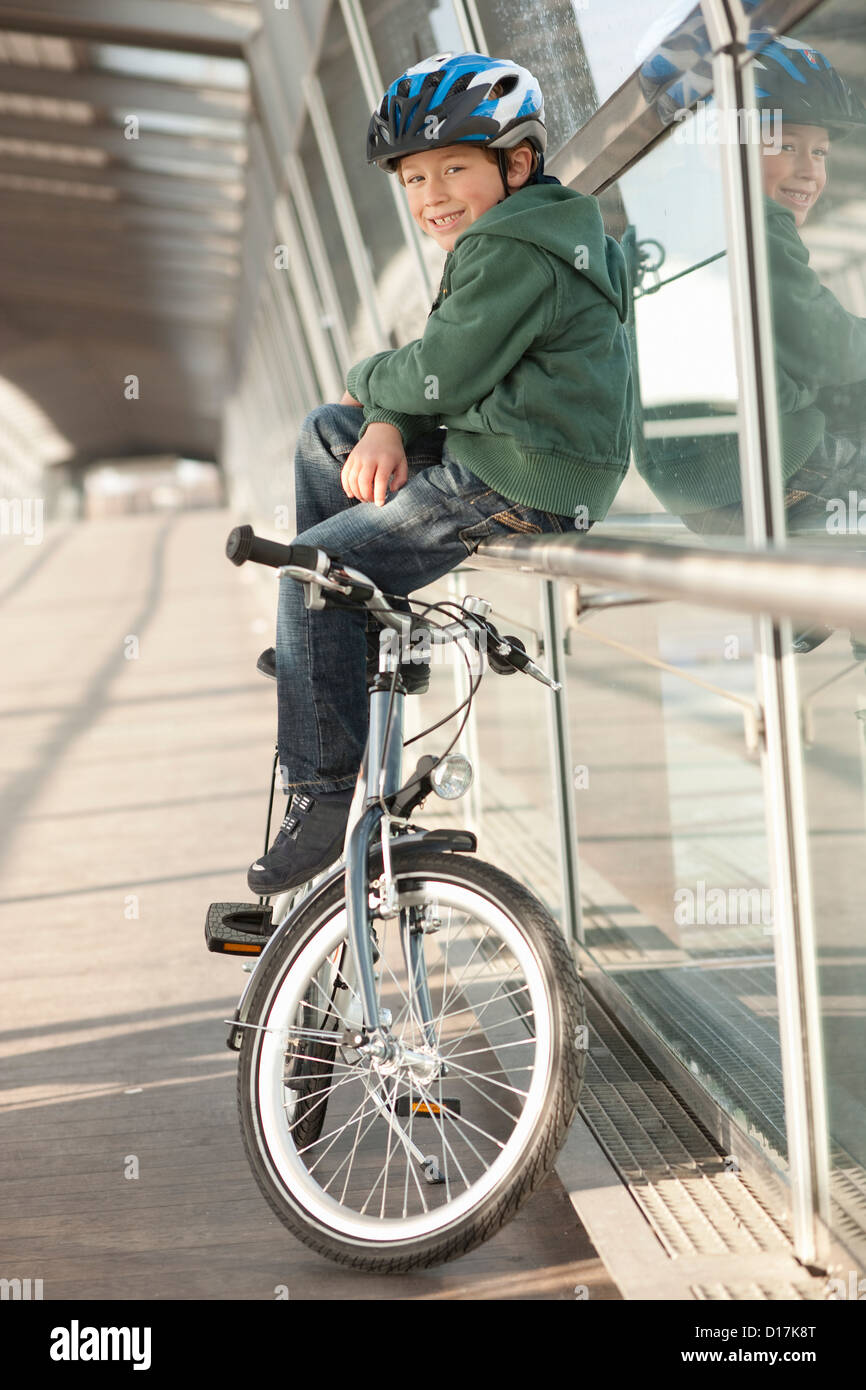 Boy sitting by bicycle in city tunnel Stock Photo