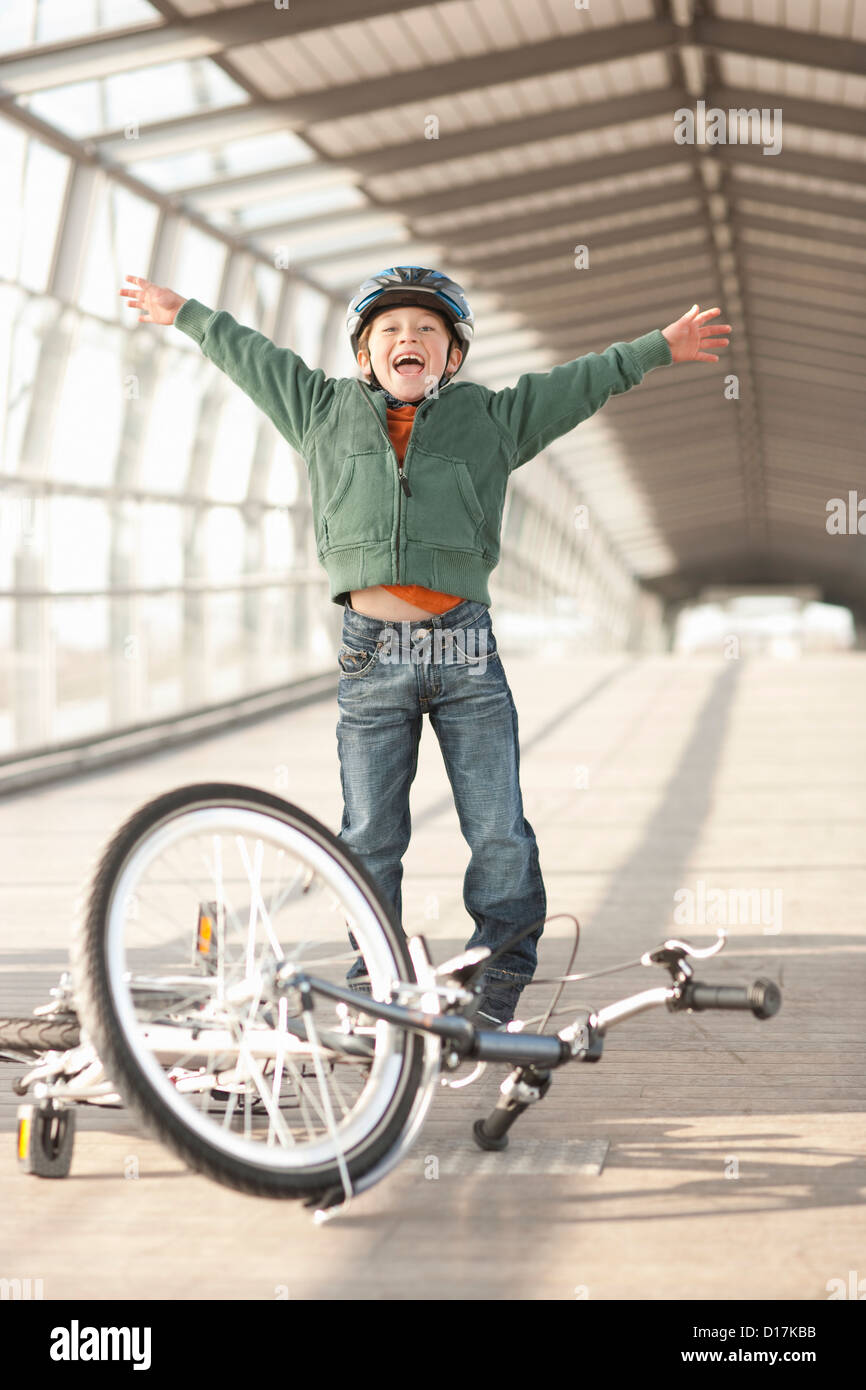 Boy cheering with bicycle in tunnel Stock Photo