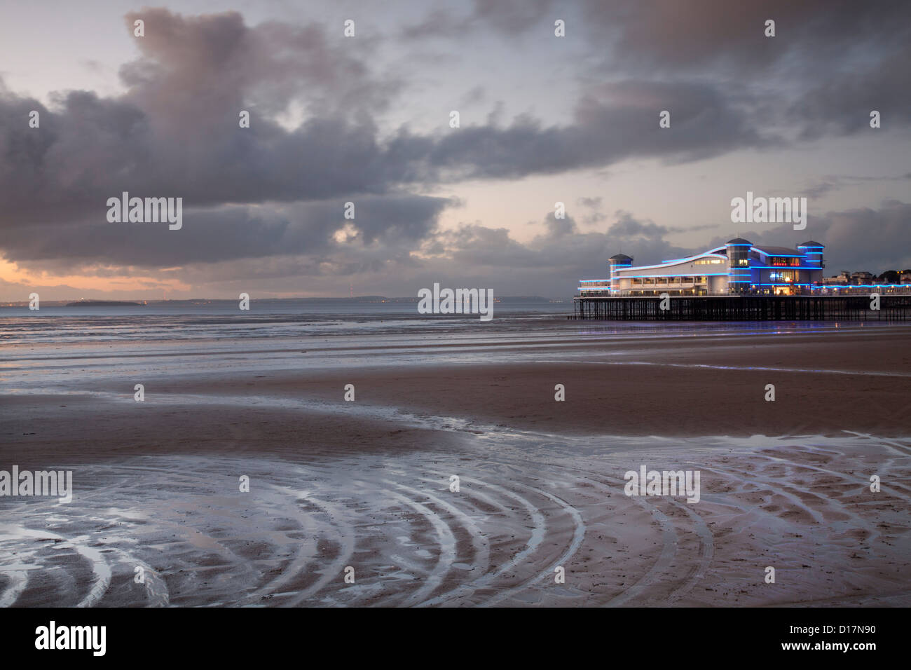 The new Grand Pier at Weston super Mare, Somerset, United Kingdom, at dusk, with a pattern of rivulets in the foreground. Stock Photo