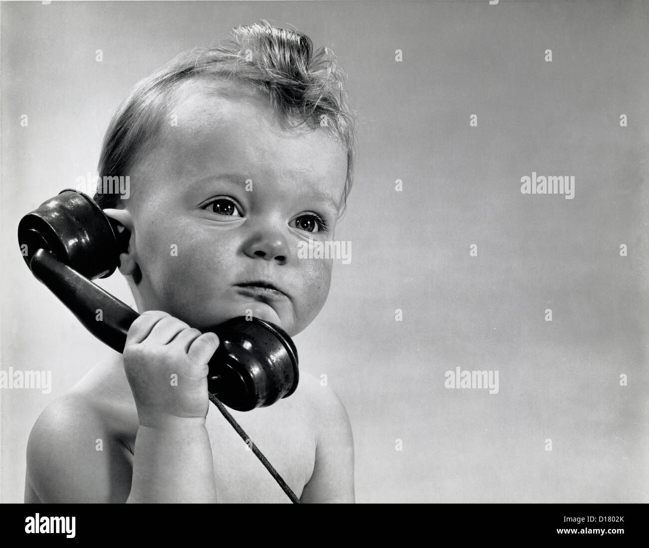 Vintage photo of baby boy talking on phone Stock Photo