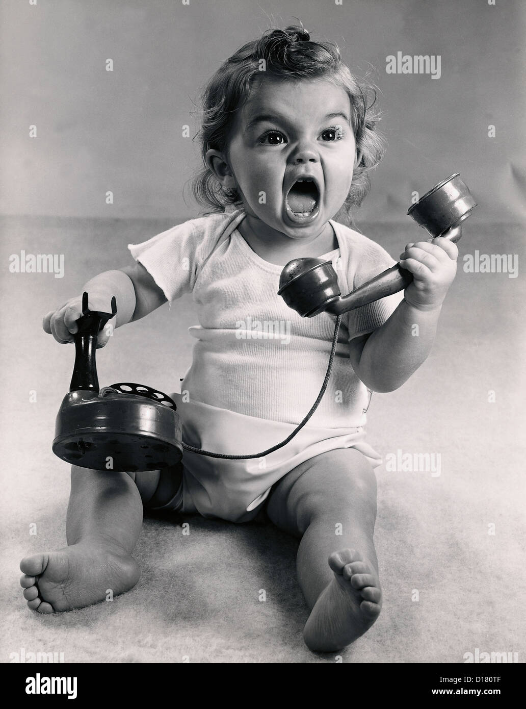 Vintage photo of infant screaming with phone Stock Photo