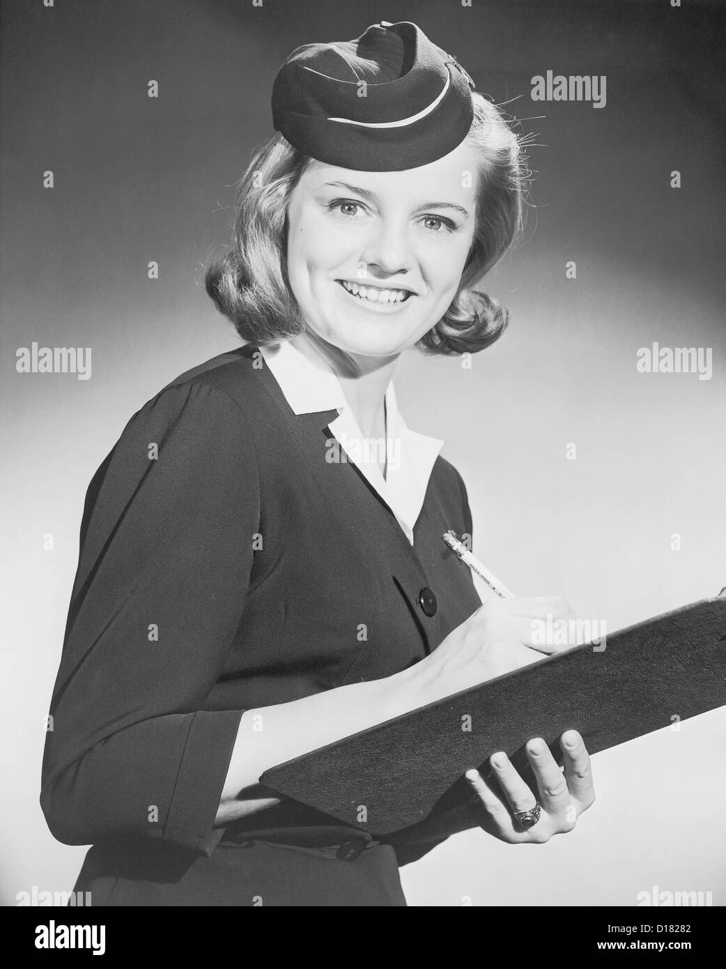 Historic portrait of airline stewardess with clipboard and pencil, 1950-1960's Stock Photo