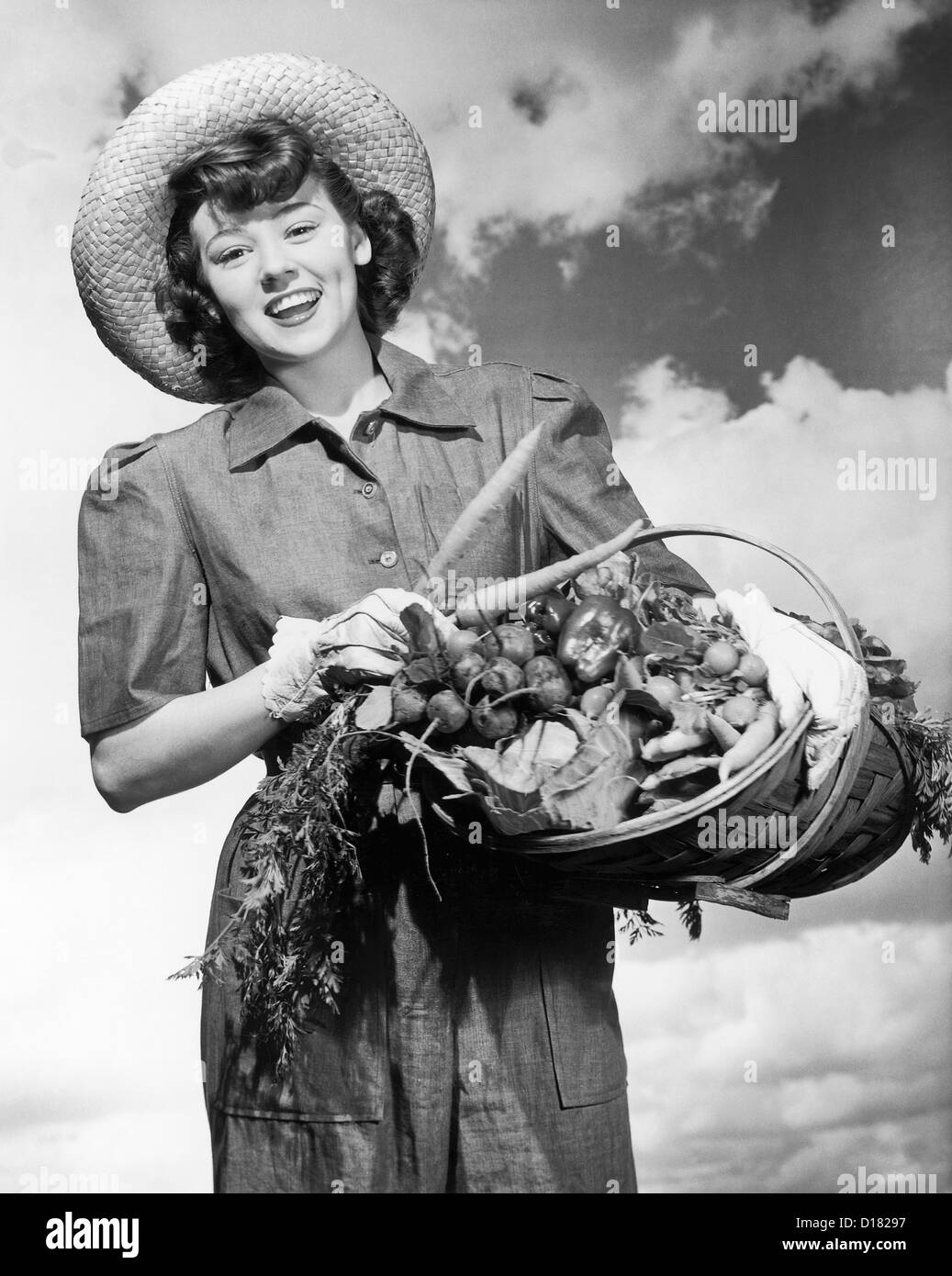 Historic portrait of woman holding a basket of fresh vegetables Stock Photo