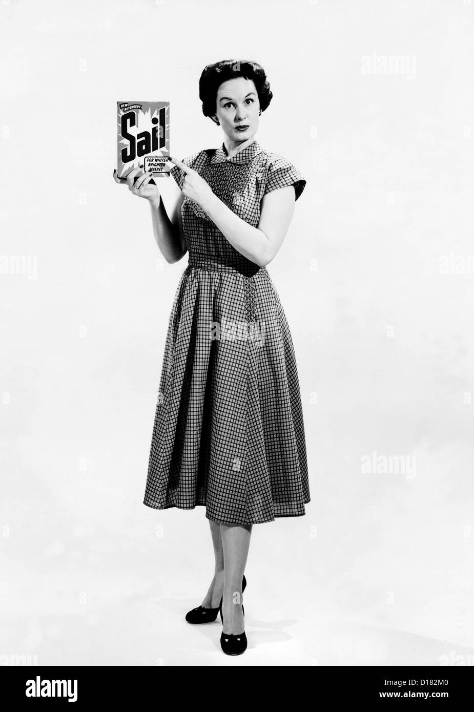 Housewife holding and pointing to detergent Stock Photo