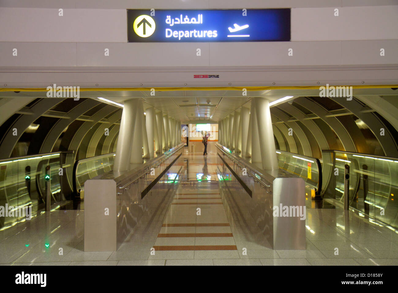 Dubai UAE,United Arab Emirates,Dubai International Airport,terminal,English,Arabic,language,bilingual,sign,arrow,departures,moving walkway,Airport Ter Stock Photo