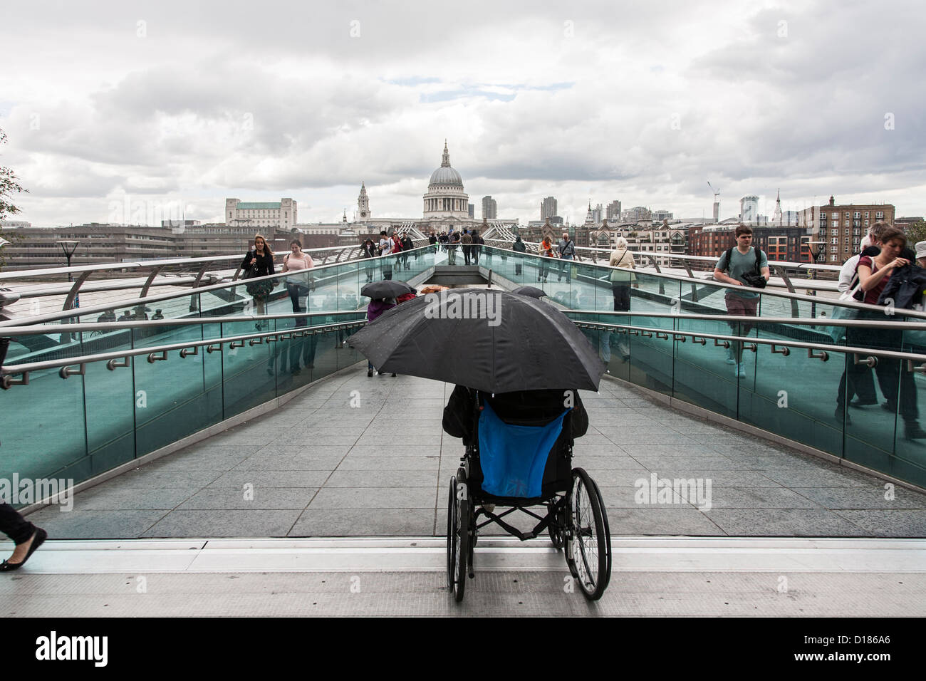 homeless man in wheelchair waiting alone in the rain with umbrella